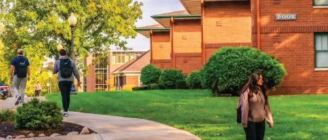 Students walking outside near campus houses.